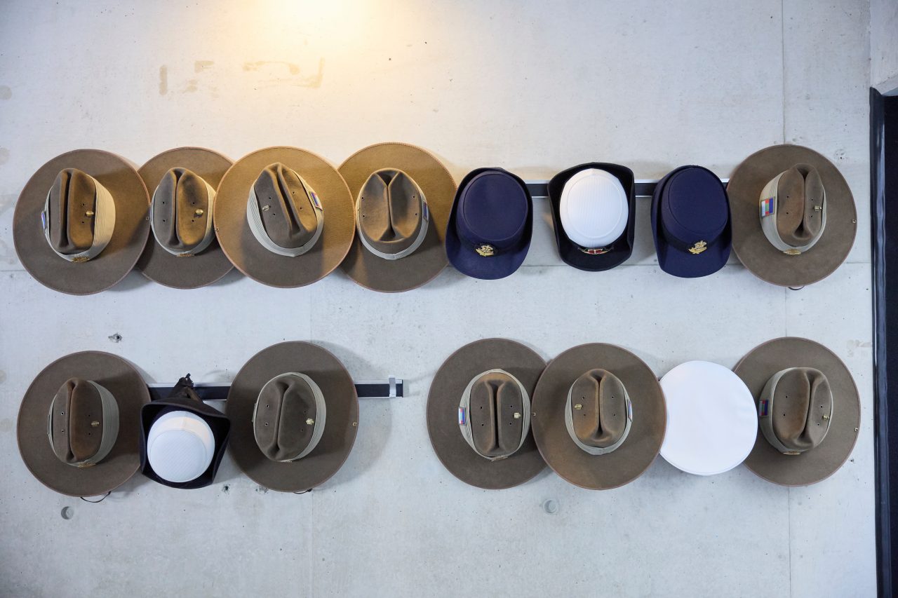 Collection of military hats hanging on a wall